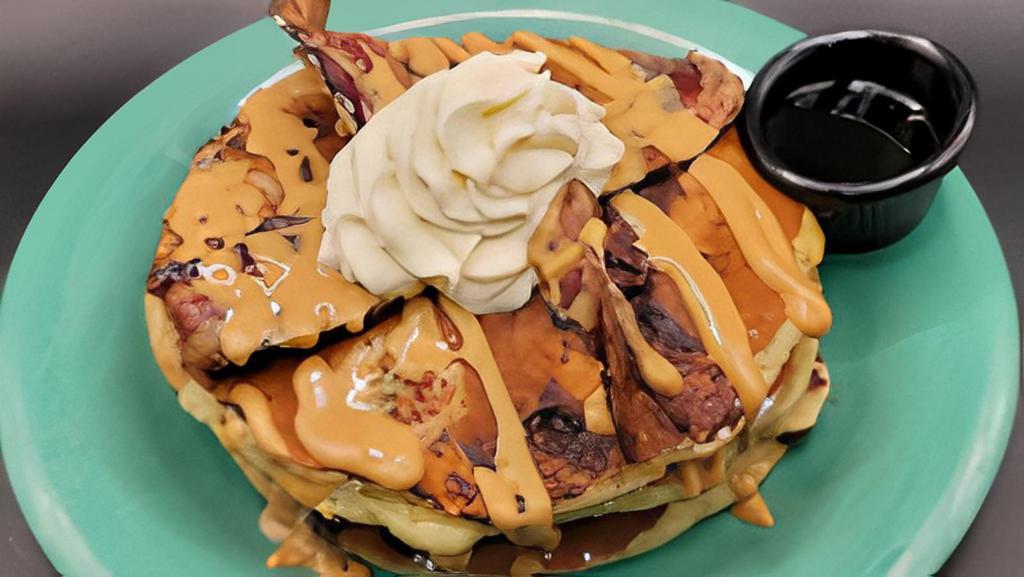 King Cakes · Three mini banana & chocolate chip pancakes – topped with bacon & finished with a peanut butter drizzle & whipped cream.