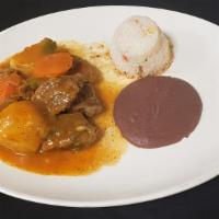 Carne Guisada · Beef stew with tomato sauce, pieces of potato and carrots.