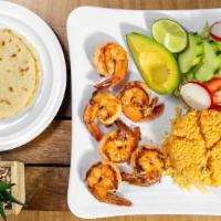 Camarones A La Plancha · Deliciously marinated grilled jumbo shrimp,  Served with rice, salad, sliced avocado, and tw...