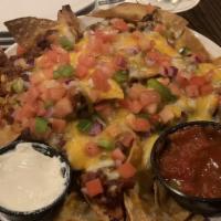 Chili Nachos Grande · Gluten Free. Freshly fried tortilla chips topped with layers of Monterey jack and cheddar ch...