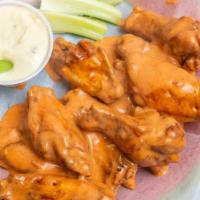 Unbreaded Buffalo Wings · Cooked wings of a chicken coated in buffalo sauce.