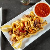 Fried Calamari · With hot cheery peppers & toasted pine nuts. Served with a lemon wedge and a side of marinar...