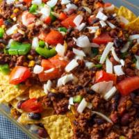 Texas Nachos · Home made tortilla chips served with black beans, guacamole, and sour cream  topped with shr...