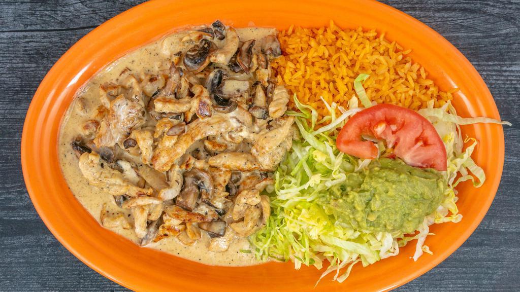Pollo A La Crema · Grilled chicken breast strips cooked with special cream sauce and mushrooms. Served with rice and guacamole salad.