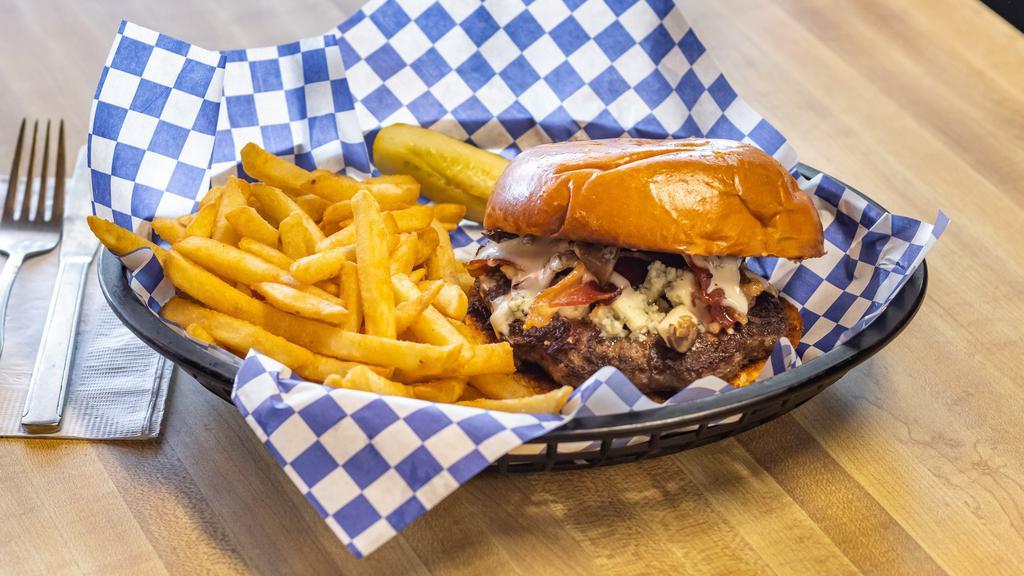 New Black & Blue Burger · 100% angus burger with crumbled blue cheese, hickory-smoked bacon, sautéed mushroom and ranch dressing. All piled on a toasted buttery brioche roll. Served with a side of fries and a pickle slice.