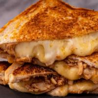 Brisket Grilled Cheese Sandwich · Braised beef multigrain sandwich decorated with red onion, American and Swiss cheese.