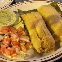 Tamales De Pollo · Two tamales stuffed with chicken.