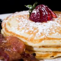 Buttermilk Pancakes · Breakfast meat, powdered sugar, fruit, and maple syrup.