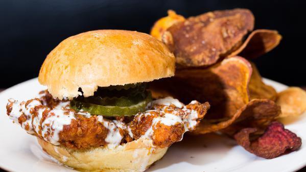 Nashville Hot Chicken Sandwich  · Spicy crispy chicken, buttermilk dressing, pickles, brioche bun, and chips.