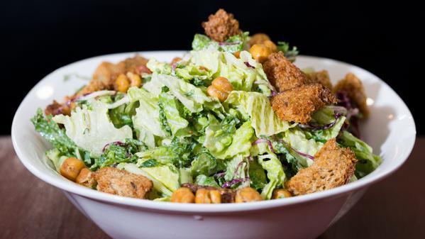 Tahini Caesar Salad · Kale, romaine, radicchio, crispy chickpeas, croutons, and lemon tahini caesar dressing.  (Vegan)