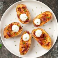 Potato Parcel · Baked potato skins filled with cheddar cheese, bacon, scallions, and topped with sour cream.