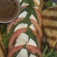 Caprese Salad · Fresh mozzarella, tomatoes, & basil leaves drizzled with olive oil and served with warm pita.