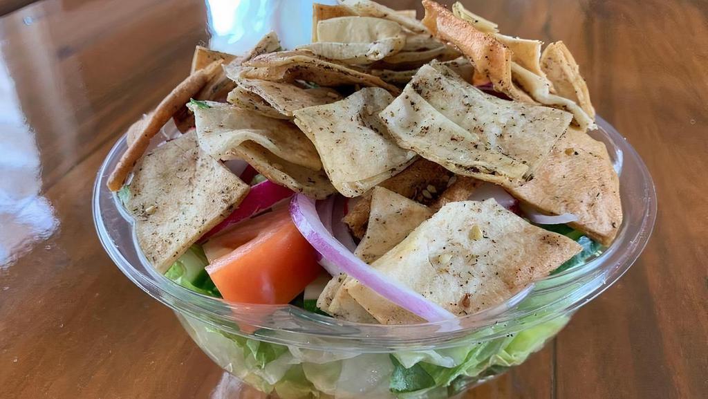 Fattoush Salad · Prepared with lettuce, tomatoes, cucumbers, radish, thyme, green peppers, parsley, olive oil, sumac and lemon juice served with thyme pita chips. Fattoush dressing on the side. Vegan.