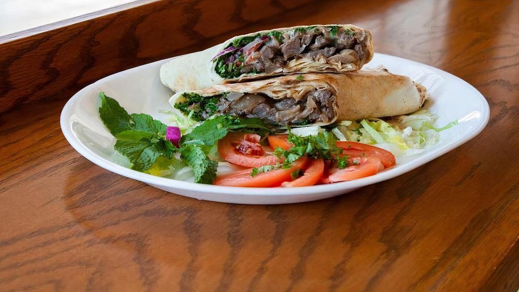 Beef Shawarma Sandwich · A pita wrap served with marinated beef, parsley, sweet red onions, tomatoes and tahini sauce.