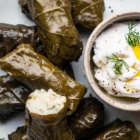 Dolmades · Grape leaves stuffed with rice and Greek spices. Served with tzatziki sauce.