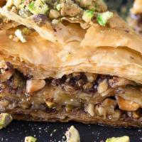 Greek Baklava · Layers of crispy golden brown phyllo dough,
filled with chopped walnuts and garnished with h...