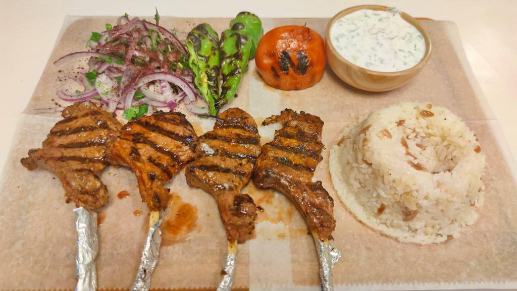 Lamb Chops · Cuts of lamb which are traditionally marinated and grilled, served with rice, cacik, onion with sumac, grilled pepper and tomato.