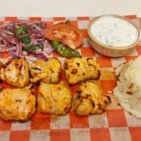 Chicken Shish Kebab · Marinated chicken cubes that are skewered and grilled and served with cacik, rice, onion, gr...