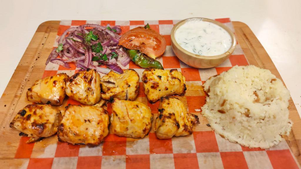 Chicken Shish Kebab · Marinated chicken cubes that are skewered and grilled and served with cacik, rice, onion, grilled tomato and green pepper.