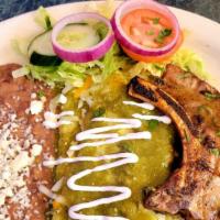 Enchiladas Puercas · Two green enchiladas served with a grilled Pork Chop and beans.