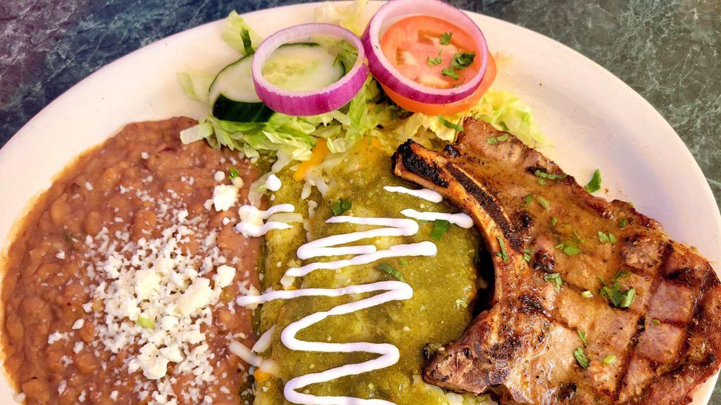 Enchiladas Puercas · Two green enchiladas served with a grilled Pork Chop and beans.
