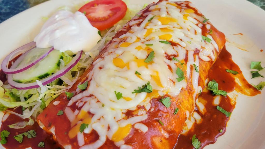 Enchilada Burrito · Delicious burrito topped with homemade enchilada sauce, melted cheese and sour cream and your choice of filling.
Meat fillings: Asada, Chicken, Chorizo, Carnitas or Veggie.