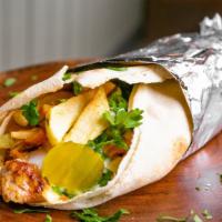 Chicken Shawarma · Marinated thinly sliced chicken on vertical broiler wrapped in a crispy pita with cabbage, p...