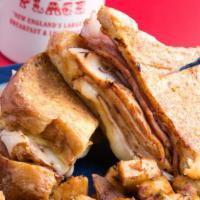 Monte Cristo · Ham, turkey and melted cheese between two slices of French toast. Shown with one side not in...