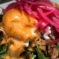 Carnitas Benedict · Chipotle hollandaise, arugula, pickled onions, and home fries.