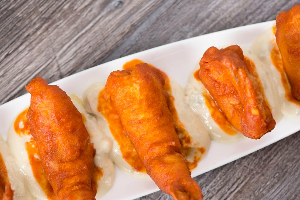 Buffalo Shrimp · Wild caught baja shrimp tossed with a spicy or mild sauce and served with a creamy roquefort sauce.
