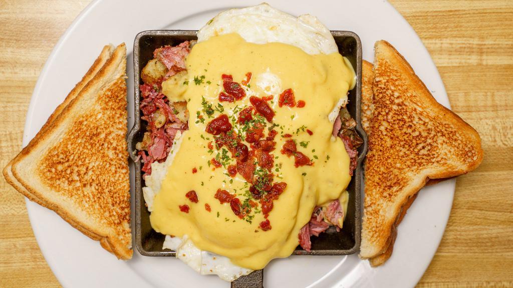 Corned Beef Hash Skillet · Home fries topped with corned beef hash, 2 eggs over easy (or your choice) topped with Hollandaise sauce and bacon bits. Choice of toast.