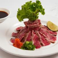 Beef Tataki · Sliced rare beef served with sliced onions, scallions and ponzu sauce.
