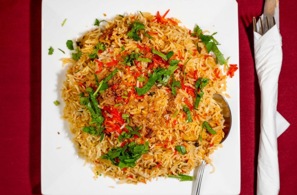 Chicken Biryani · Basmati rice cooked with chicken mixed with onion, cashew nuts and raisins, flavored with saffron and delicate spice.