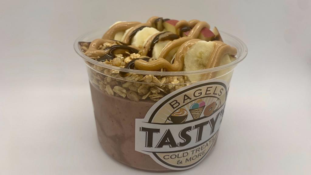 Peanut Butter Kiss · Acai, almond milk,  banana, peanut butter, sliced apples, sliced banana, granola, chocolate sauce drizzle, honey drizzle. (Banana is used in base of bowl)