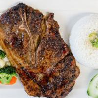 Lemongrass Pork Steak · Bone-in pork chop, served with ginger scalllion rice, and steamed vegetables.