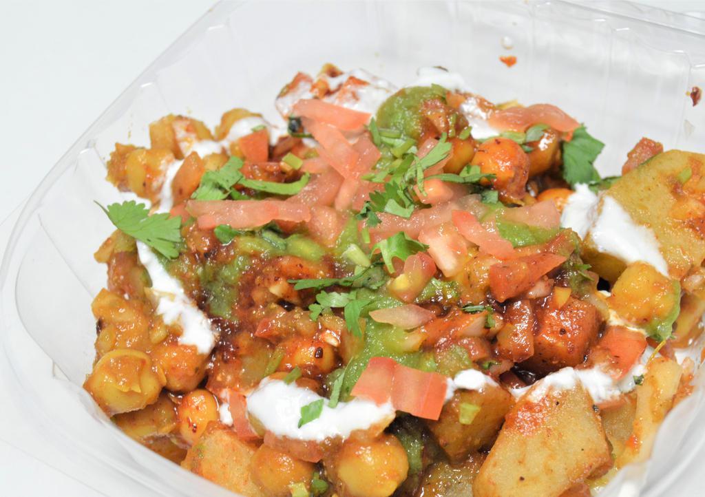 Aloo Chat · Spicy.  A refreshing chat item,  made with fried potatoes,  chickpeas in a yogurt sauce and lightly spiced. Chickpeas, onion, tomatoes, yogurt, Fried Potatoes, salt, spices, tamarind chutney, coriander chutney.