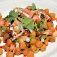 Samosa Chat · Spicy. Chickpeas topped with samosas, onions, tomatoes, cilantro, yogurt, sweet and savory c...
