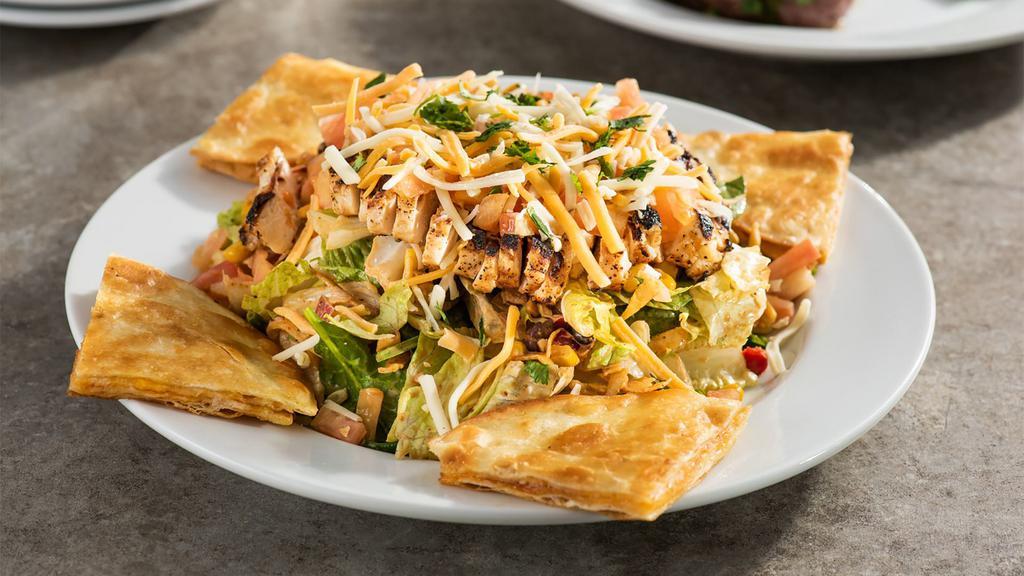 Quesadilla Explosion Salad™ · Favorite. Grilled chicken, cheese, tomatoes, corn, and black bean salsa, tortilla strips with citrus-balsamic. Then, boom, topped with our cheese quesadillas. 1410 cal.