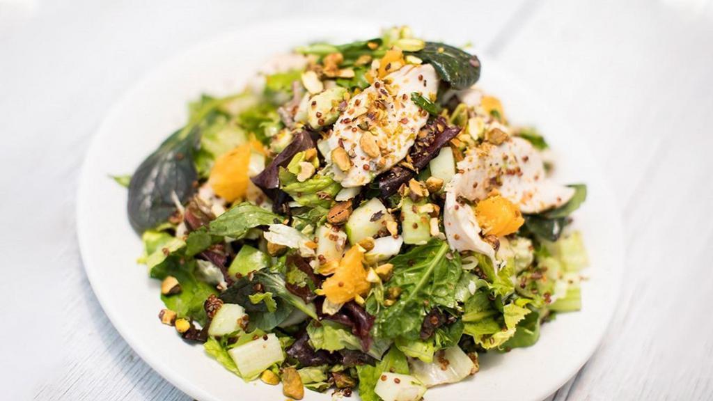 Super Crunch · chopped salad with grilled chicken, quinoa, apples, pistachios, avocado, spinach, oranges, cukes, mint, cilantro and orange-sesame dressing.