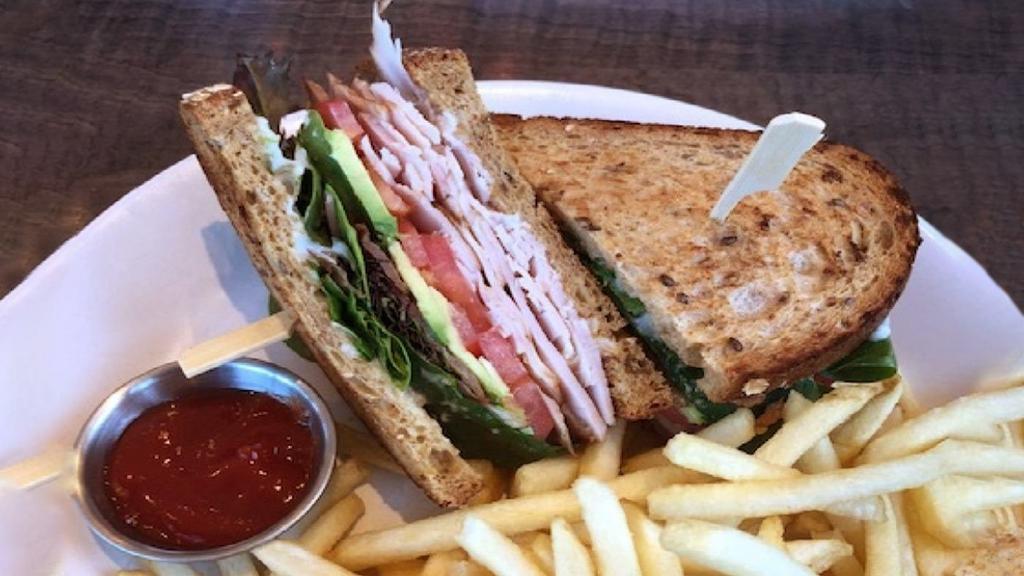 Turkey Avocado Club · house-roasted turkey, avocado and country bacon with lettuce, tomato and mayo on toasted multigrain bread with fries.