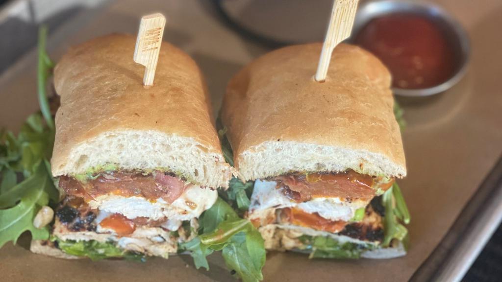 Chicken Caprese · grilled chicken with melted fresh mozzarella, marinated tomatoes, pesto aioli and arugula on toasted ciabatta with fries or vegetarian style with extra cheese and tomatoes.
