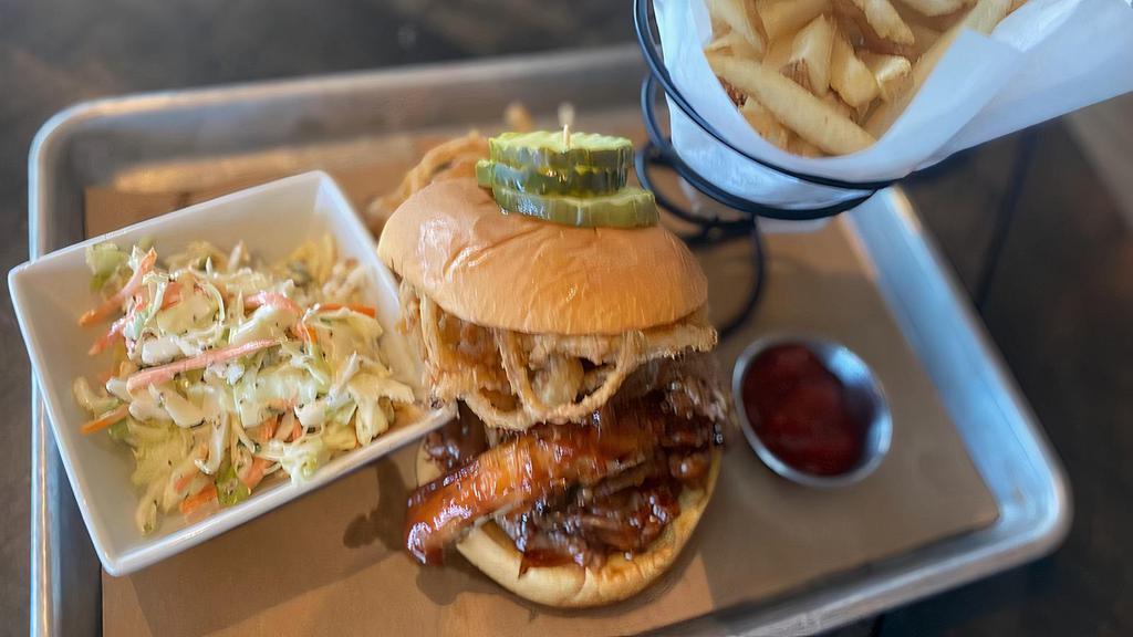 Bbq Pulled Pork Sandwich · tangy shredded pork on a martin's potato roll topped with crispy onion strings, slaw and pickles, served with fries.