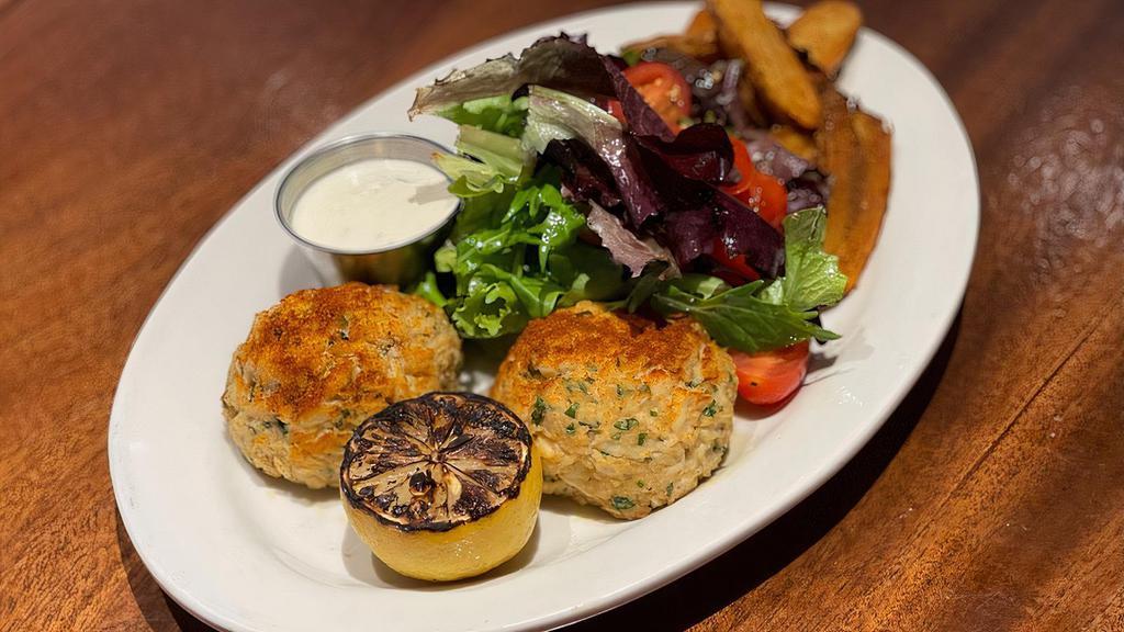 Jumbo Lump Crab Cakes · two 4oz pan-seared maryland style crab cakes with old bay potato wedges, simple green salad and lemon aioli.