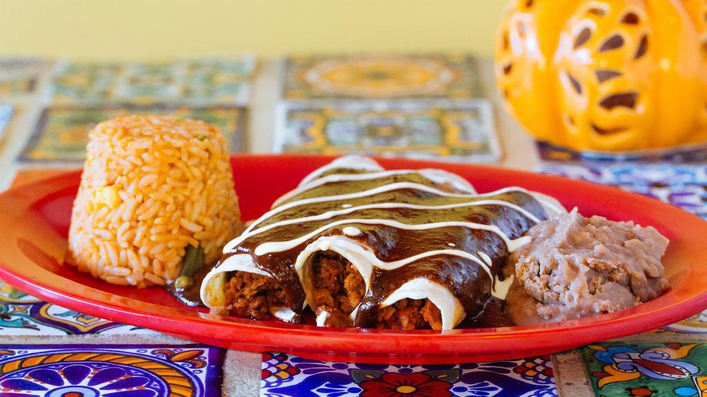 Enchiladas · Three soft corn tortillas topped with cheese, sour cream and the sauce of your choice of mole or tomatillo. Served with rice and beans.