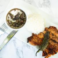 Pollo A La Plancha · Grilled chicken breast served with rice, salad, and beans.