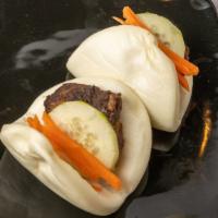Pork Bao Buns · Two pork belly buns garnished with pickled vegetables.
