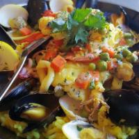 Catalan Seafood Paella · Traditional dish with white fish, shrimps, mussels, calamari, clams, veggies, herbs and lemo...