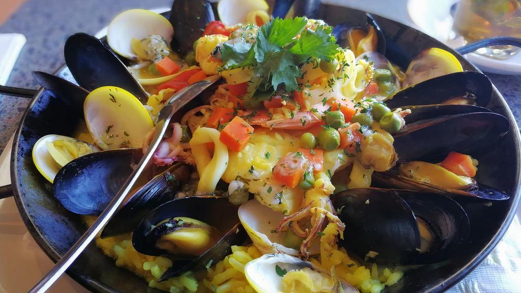 Catalan Seafood Paella · Traditional dish with white fish, shrimps, mussels, calamari, clams, veggies, herbs and lemon rice.