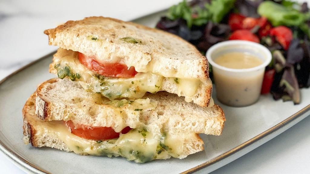 Fontina Grilled Cheese · Fontina cheese, sliced tomato, & MAMAmade basil pesto on grilled sourdough bread, served with a side salad