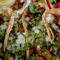 Tacos · Tacos tradicionales mexicanos, servidos con cilantro fresco, cebolla, pepino, rábano y limón...